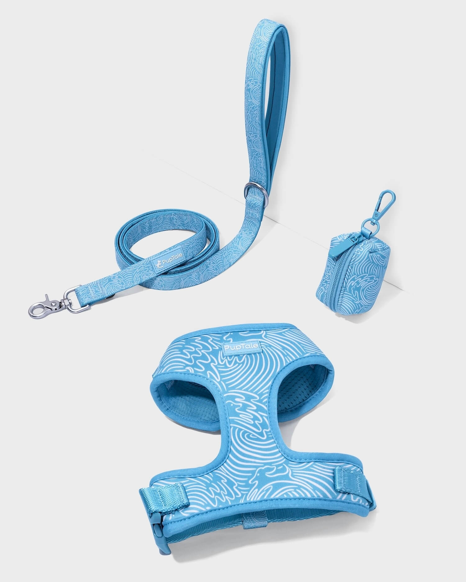A set of blue puppy harness and leash with a wave pattern, including adjustable straps and a matching leash clip.
