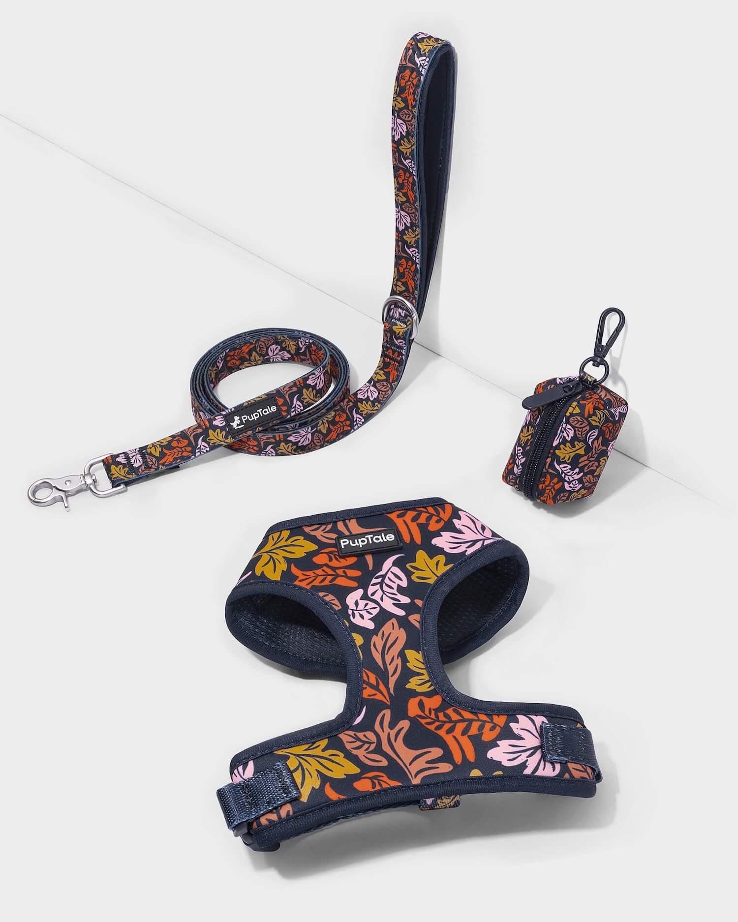 A dog harness and leash set with a fall leaf pattern in blue and pink colors, displayed on a white background.